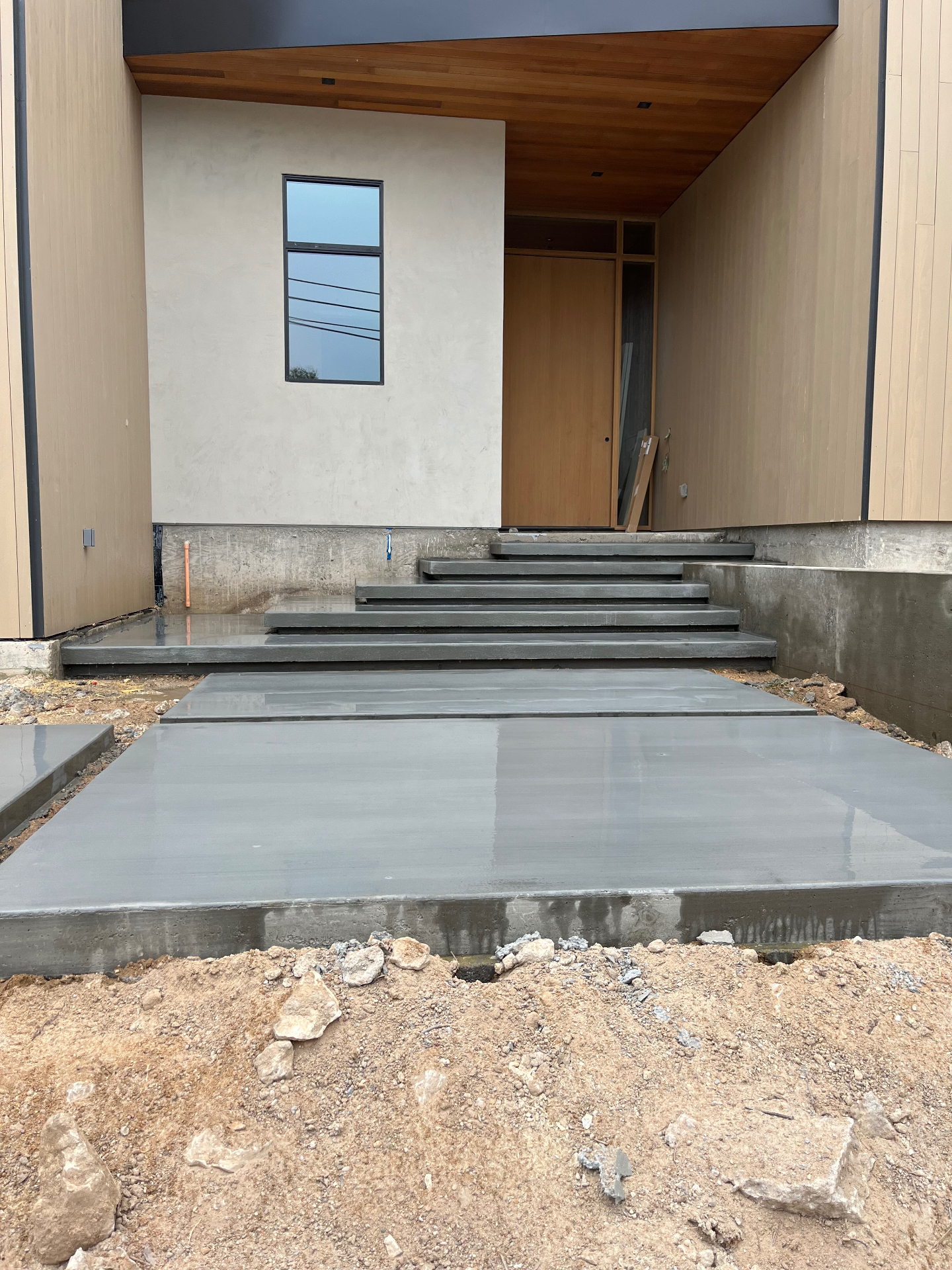 Custom poured concrete entry steps and walkway with smooth modern finish