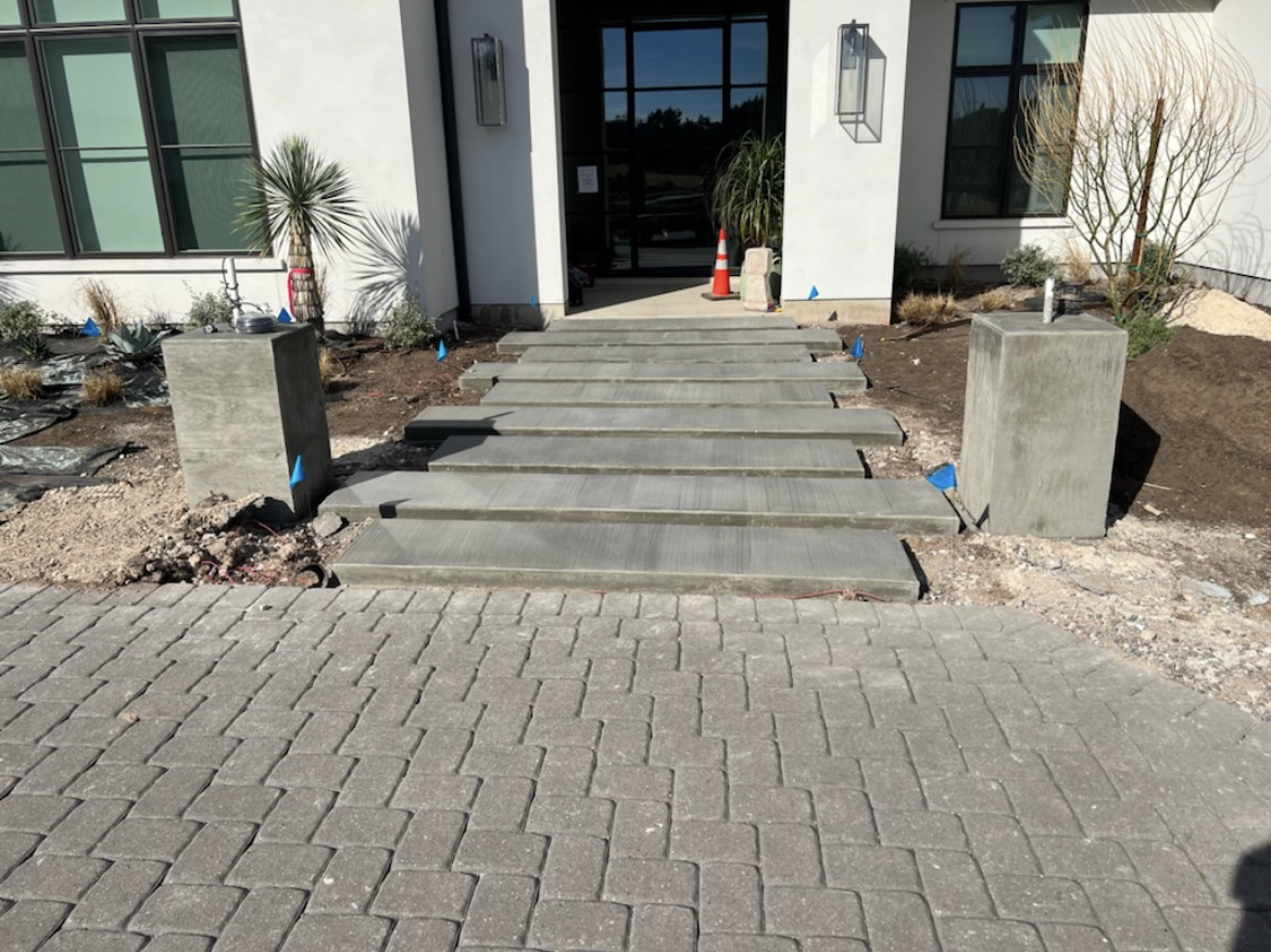Custom floating concrete entry steps flanked by poured concrete posts